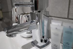 einen silbernen Zahnbürstenhalter auf einem Waschbecken in der Unterkunft Halifax House, Studio Apartment 215 in Halifax