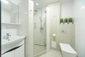 a bathroom with a shower and a toilet and a sink at ARTAL Apartment on Iordanskaya 22 in Kyiv +12 photos