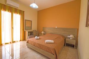 a bedroom with a bed with two towels on it at Souda Bay Loggia in Sellía