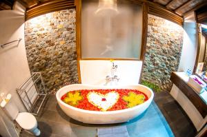 a bathroom with a bath tub filled with flowers at Puri Kobot in Ubud