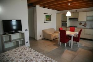 a living room with a table and chairs and a kitchen at Ca' Vittori in Valeggio sul Mincio
