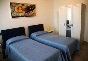Habitación con 2 camas y una pintura en la pared. en Ca' Vittori, en Valeggio sul Mincio