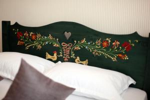 - un lit avec une tête de lit verte et des fleurs dans l'établissement Casa Cu Usi - House of Doors, à Sighişoara