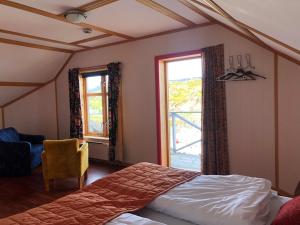 ein Schlafzimmer mit einem Bett und zwei Fenstern in der Unterkunft Arran Nordkapp in Honningsvåg