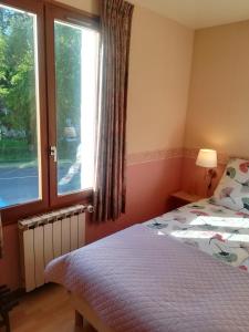 a bedroom with a bed and a window at Hotel La Croix des Bois in Lalizolle