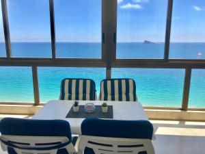 ベニドルムにあるLos Gemelos 1 - Aloturin Benidormの海の景色を望む客室で、テーブルと椅子が備わります。