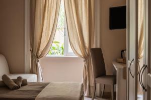 Un dormitorio con una cama y una ventana con una silla. en Sogno di un'epoca, en Roma