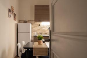 een keuken met een tafel en een witte koelkast bij Sogno di un'epoca in Rome