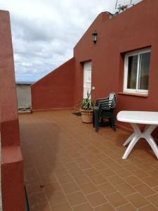 eine Terrasse mit einem Tisch und Stühlen auf einem Gebäude in der Unterkunft El Cercado la montaña 4 Las Puntas in Las Puntas