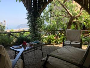 a patio with a table and two chairs and a table and a view at Agriturismo L'Olivara in Piano di Sorrento