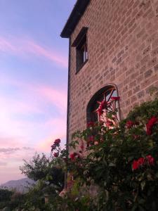 a brick building with a window with flowers in front at Agriturismo L'Olivara in Piano di Sorrento +53 photos