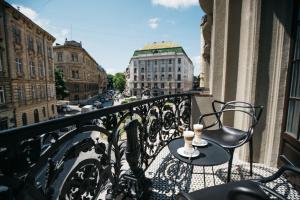 a balcony with a table and a chair on a balcony at Gruner Hotel in Lviv +30 photos