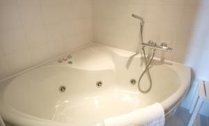 a bath tub in a bathroom with a shower at Le Windsor, Jungle Art Hotel in Nice