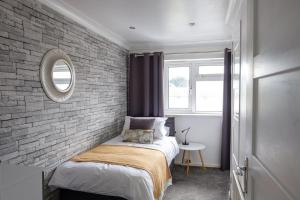 Dormitorio pequeño con pared de ladrillo en Modern & Elegant 3BR 15mins close to Gatwick- Dickens House en Crawley