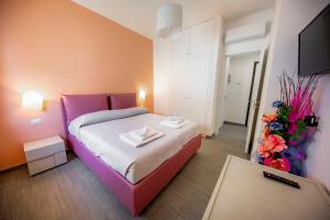 1 dormitorio con 1 cama de color púrpura y TV en House Giardina, en Cefalú