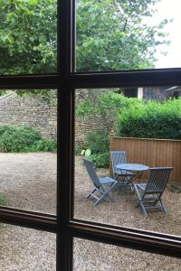 einen Blick auf zwei Stühle und einen Tisch aus dem Fenster in der Unterkunft La Chambre des Buissonnats in Martailly-lès-Brancion