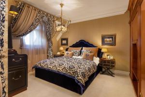 a bedroom with a king sized bed and a chandelier at Suter Palace Heritage Boutique Hotel in Bucharest