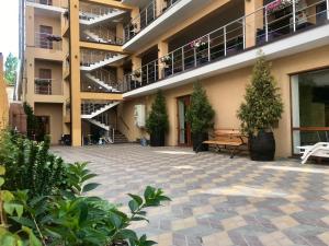 a courtyard of a building with a bench and potted plants at Золотий ЛЕВ in Zatoka
