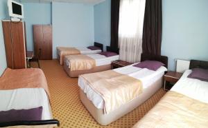 a group of four beds in a room at Esin Pansiyon in Tokat
