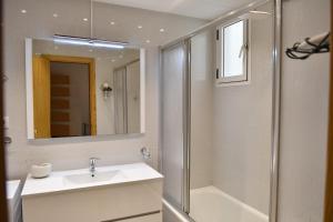 łazienka z umywalką i prysznicem oraz lustrem w obiekcie Appartement exceptionnel confortable bord de mer w mieście Sant Carles de la Ràpita