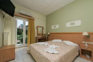 ein Hotelzimmer mit Bett und Fernseher in der Unterkunft Plaz Hotel in Selianitika