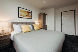 a bedroom with a large white bed with yellow pillows at Halifax House, One Bedroom Apartment 216 in Halifax