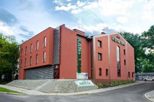 un edificio rojo con un cartel en el costado en Hotel&Spa Kameleon, en Żory