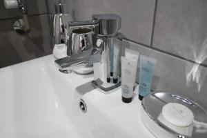 a bathroom sink with two toothbrushes and a faucet at Halifax House, One Bedroom Apartment 216 in Halifax