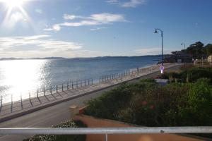 a road next to the ocean with a fence at Les Stoechades in Hyères