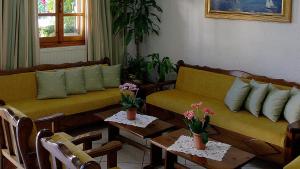 a living room with two couches and tables with flowers at Effie Hotel in Skala