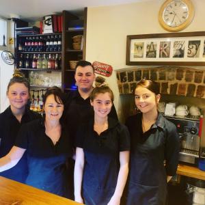 a group of people standing in front of a bar at Bridge View Guest House in Ironbridge