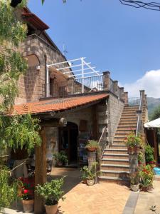a stone house with stairs and a balcony at Agriturismo L'Olivara in Piano di Sorrento