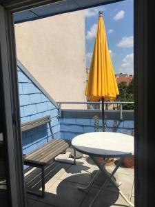 a table and a yellow umbrella on a balcony at Grazer Schwalbe in Graz