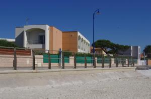 a fence in front of a building next to a beach at Les Stoechades in Hyères