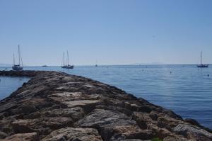 a rocky pier with boats in the water at Les Stoechades in Hyères