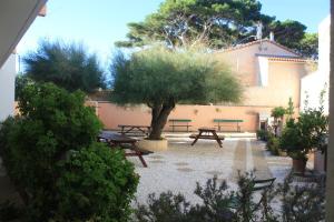 a courtyard with picnic tables and a tree at Les Stoechades in Hyères
