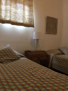 
a bedroom with two beds and a lamp at Guest House D'Avenida in Vila Praia de Âncora
