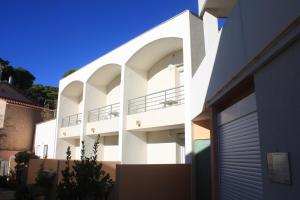a white building with balconies on the side of it at Les Stoechades in Hyères