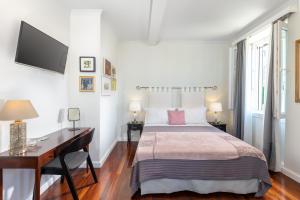 a bedroom with a bed and a desk and a tv at Dousmani Corfu Old Town Studio Suite in Corfu Town