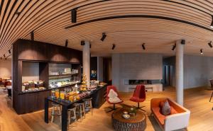 a lobby with a bar with red chairs and tables at 2ND HOME HOTEL - Ihr 4 Sterne Hotel in Nördlingen als zweites Zuhause in Nördlingen