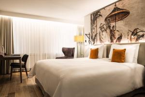 ein Hotelzimmer mit einem großen Bett und einem Schreibtisch in der Unterkunft Hotel Astoria in Luzern