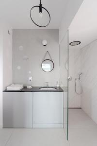 biała łazienka z umywalką i prysznicem w obiekcie UP'arts we Wrocławiu