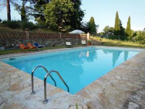 a large swimming pool with blue water in a yard at La Fontaiola in Le Piazze