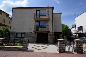 a large house with a gate and a balcony at U ELŻBIETY in Łeba