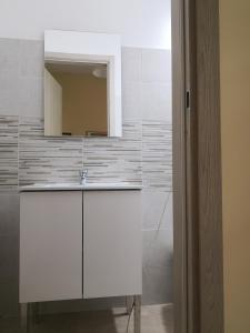 a white bathroom with a sink and a mirror at House on Anagnino 64 in Ciampino