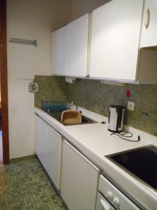 una cocina con armarios blancos y fregadero en Apartment in Anzère, en Anzère