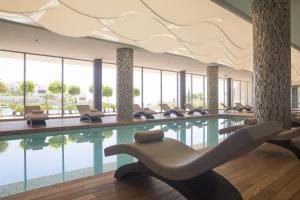 a pool in a hotel with chairs and a swimming pool at ON'LIVE HOTEL in Çeşme