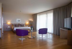 a hotel room with a bed and two purple chairs at ON'LIVE HOTEL in Çeşme