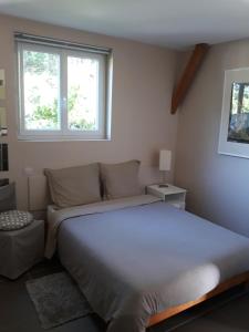 a bedroom with a large bed and two windows at Chalet Rocamadour in Lanzac