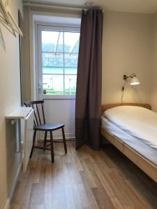 摩爾比蘭加的住宿－Ölands Yoga Studio & Islandshästar, Stugor & Rum，卧室配有床、椅子和窗户。